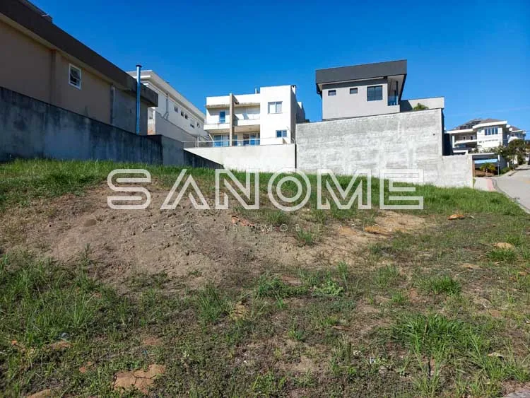 Terreno com grama e construções ao fundo