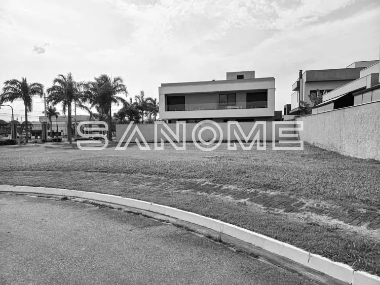 Terreno com frente em asfalto e construção ao fundo