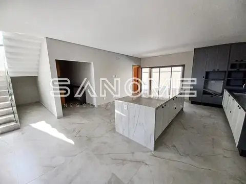 Cozinha aberta com bancada e piso em mármore