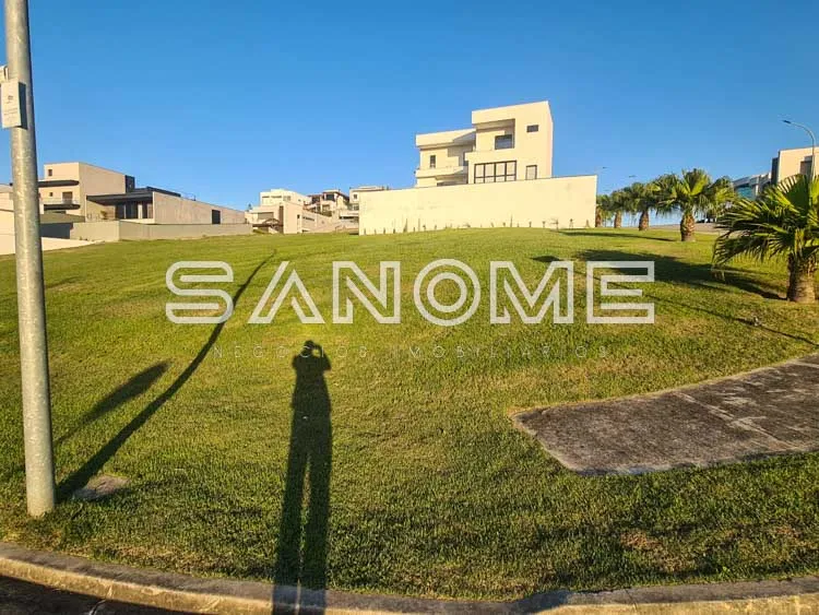 Terreno amplo com gramado e residências ao fundo