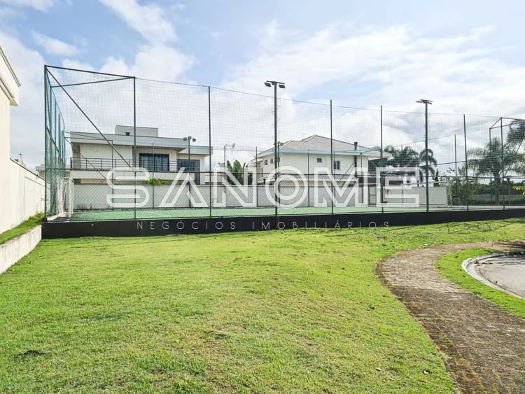 Terreno com quadra de esportes e grama verde