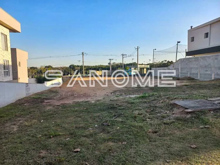 Terreno com construções ao fundo e cerca lateral