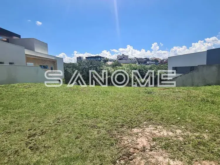 Terreno gramado com casarões modernos ao fundo