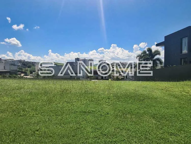 Terreno com grama verde e casa moderna ao fundo