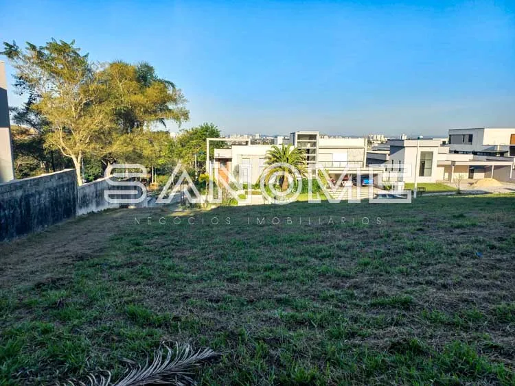 Terreno com grama e construções ao fundo