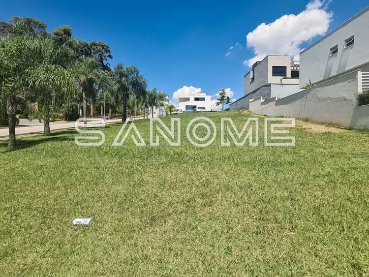 Terreno plano com grama e construção ao fundo