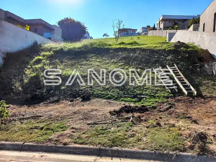 Terreno com grama e construções ao fundo