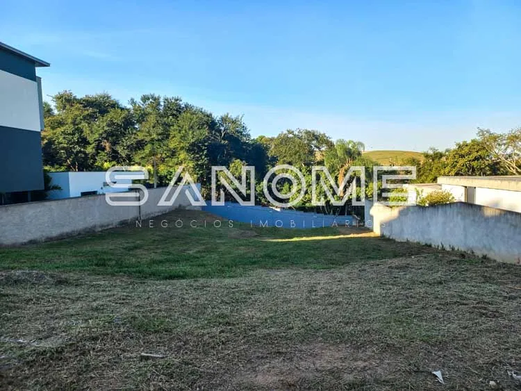 Terreno com muro branco e área gramada