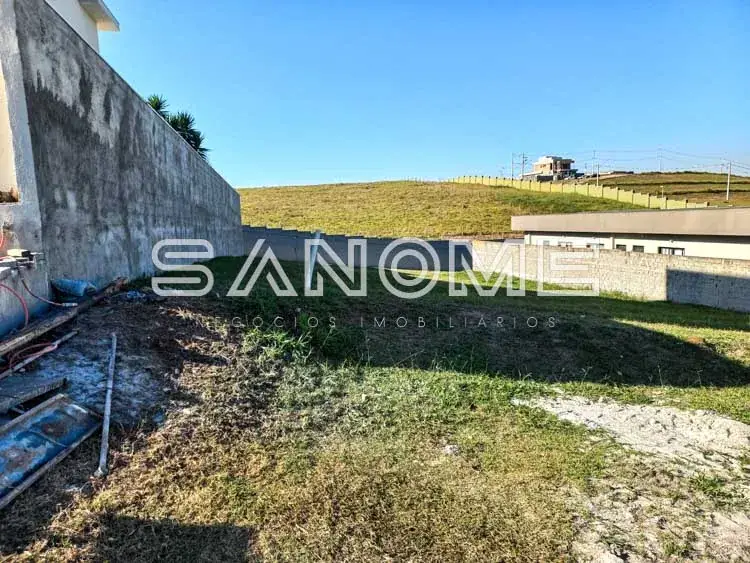 Terreno com construção e galpão ao fundo