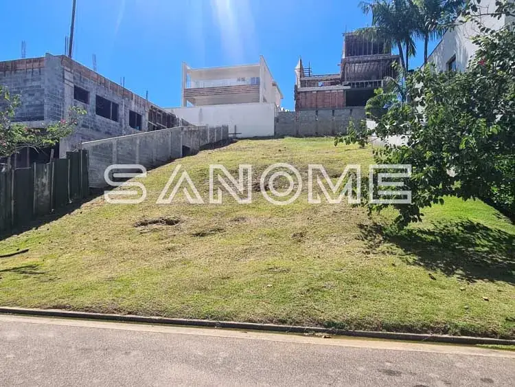 Terreno com grama e construções ao fundo