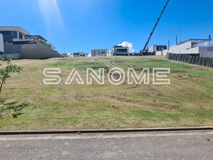 Terreno gramado com casarões ao fundo