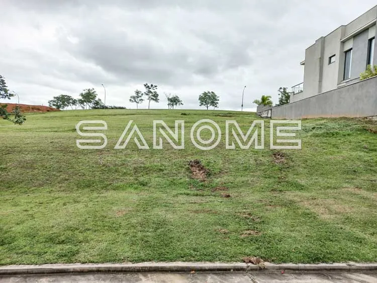 Terreno com grama e casa ao fundo