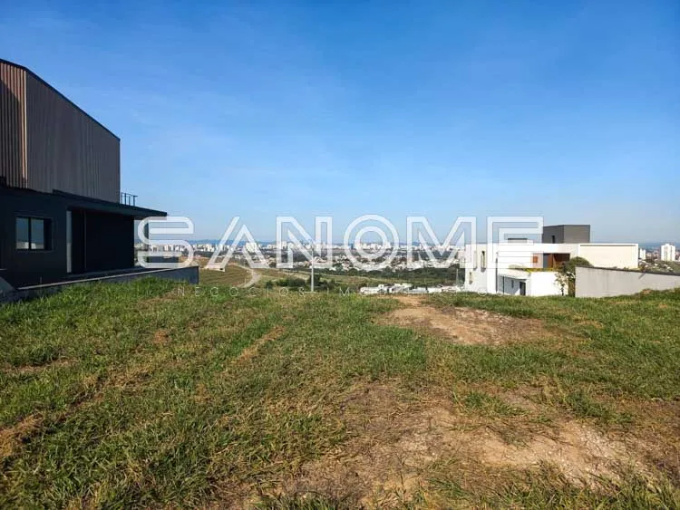 Terreno com construção residencial moderna ao fundo