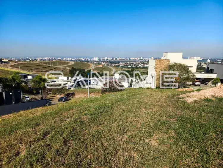 Terreno com grama e vista para cidade ao fundo