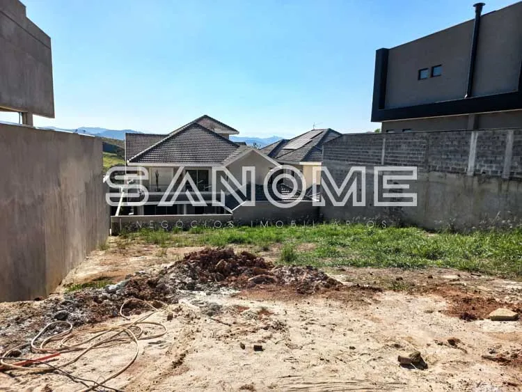 Terreno com cercamento e construções ao fundo