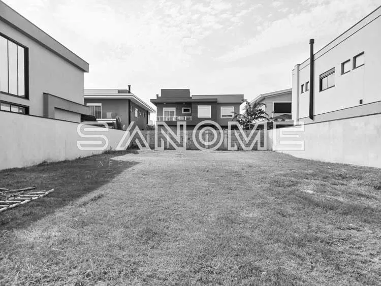 Terreno com construções residenciais ao fundo