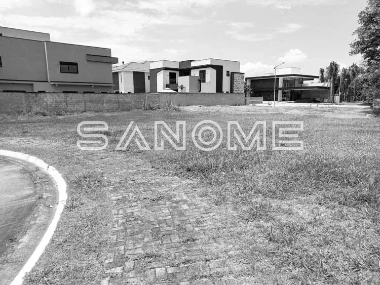 Terreno com construção em andamento e casarões ao fundo