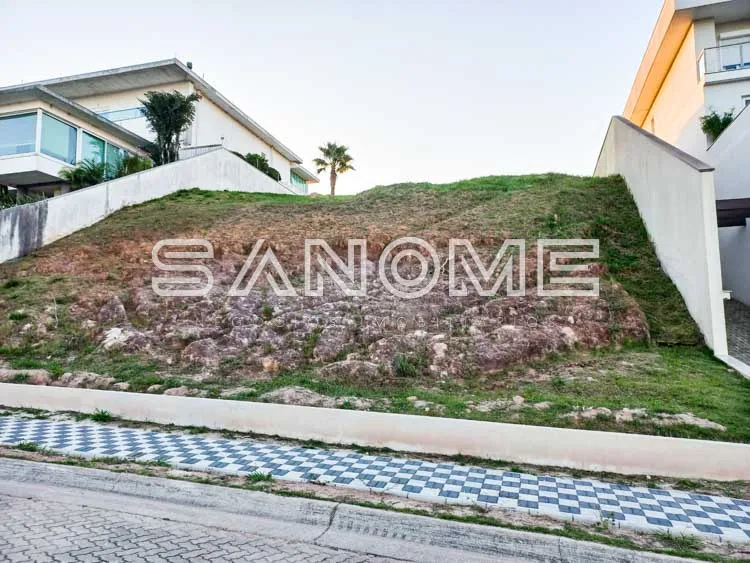 Terreno com aclive e casarões ao fundo