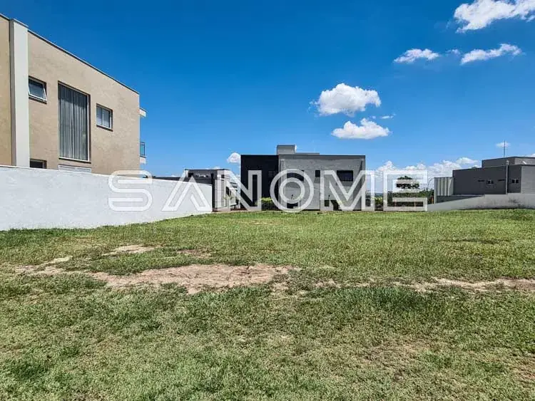 Terreno com gramado e edificações ao fundo