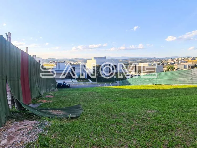 Terreno com grama e estrutura de construção ao fundo