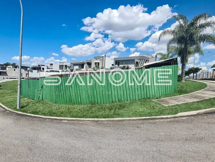 Placa de sinalização em terreno com casarões ao fundo