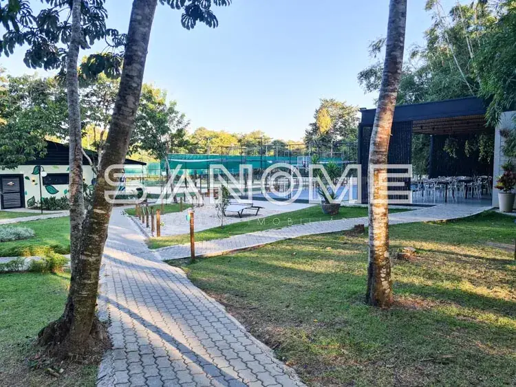 Área de lazer em condomínio com piscina e vegetação