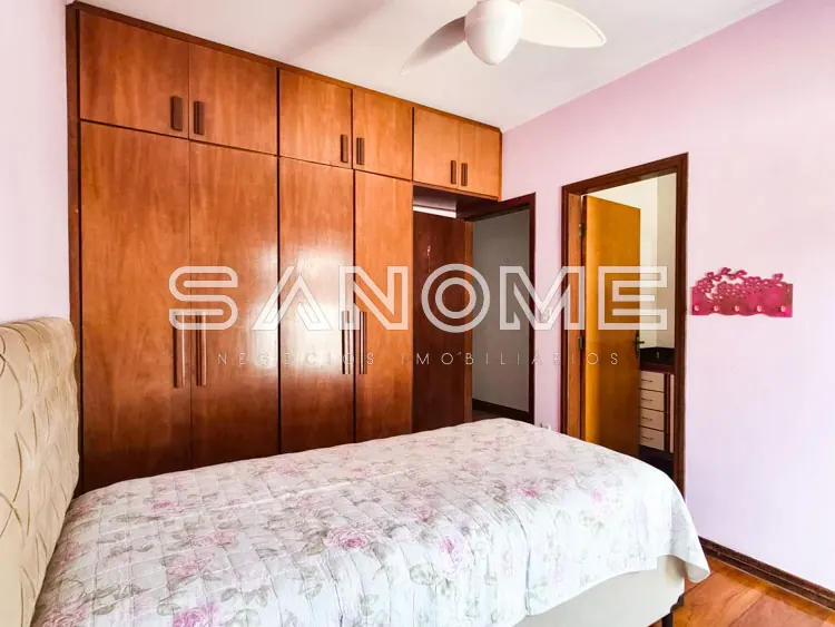 Quarto com guarda-roupa de madeira e parede rosa