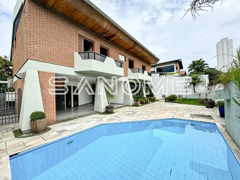 Casa com piscina e área externa pavimentada