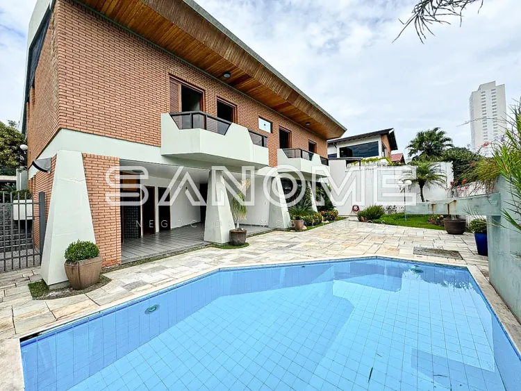 Casa com piscina e área externa pavimentada