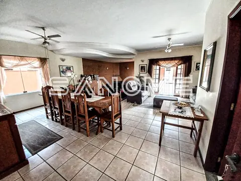 Sala de jantar com mesa de madeira e ventiladores