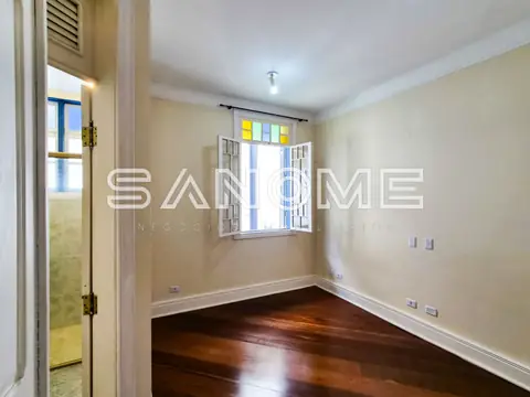 Sala vazia com piso de madeira e paredes bege