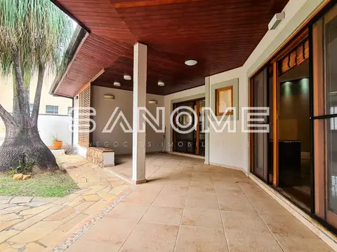 Varanda coberta com piso de cerâmica e pilares