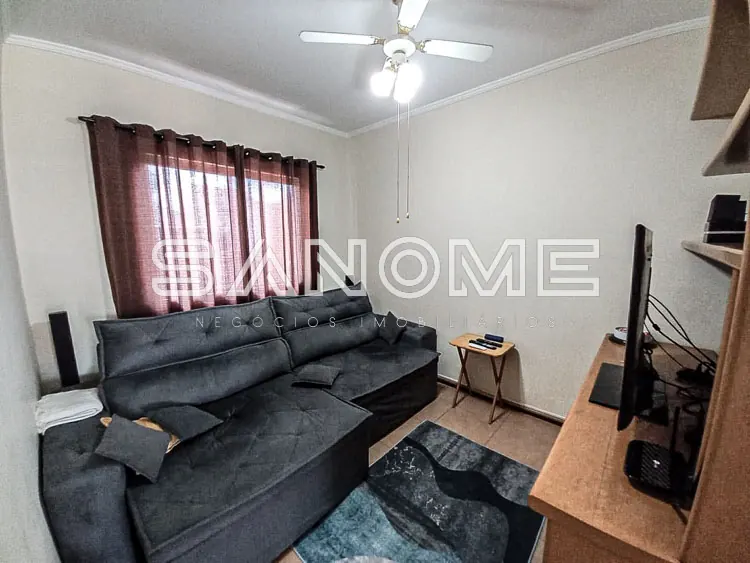 Sala de estar com sofá cinza e televisão