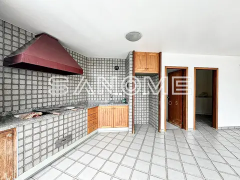Cozinha com bancada, armários em madeira e azulejos