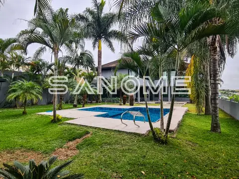 Propriedade com piscina, gramado e palmeiras
