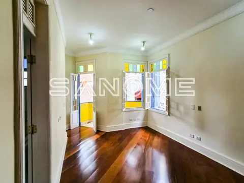 Corredor com portas e janelas coloridas, piso de madeira