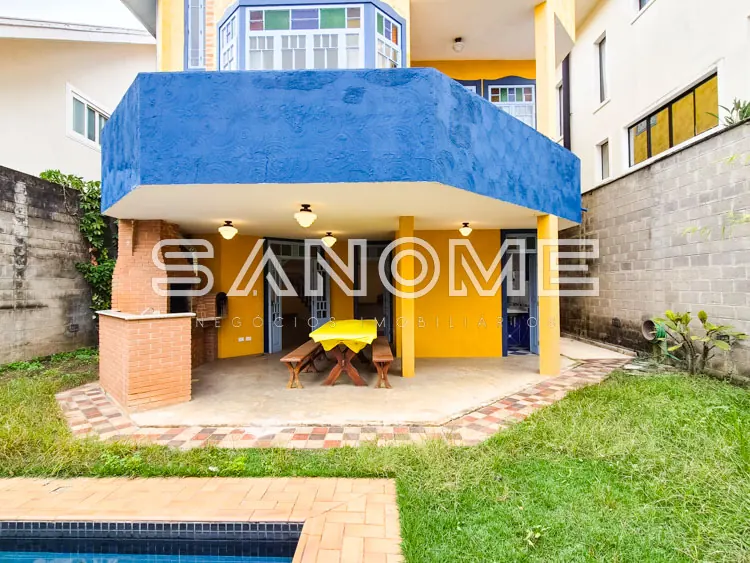 Área externa com cobertura azul e piso em tijolos