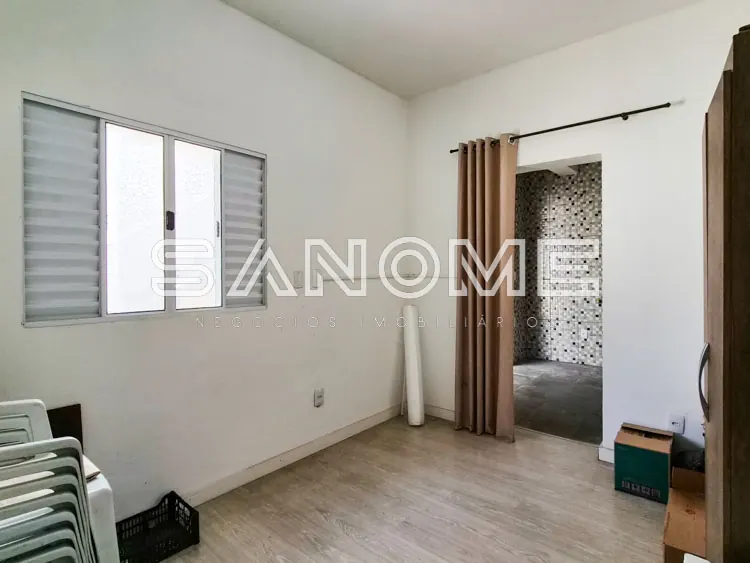 Quarto com janela, cortina e banheiro integrado