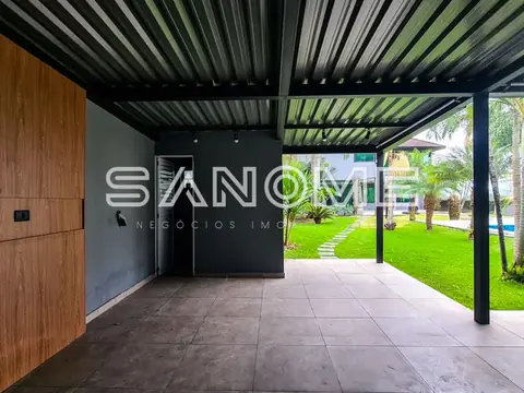 Área de cobertura com piso cinzento e paisagem verde