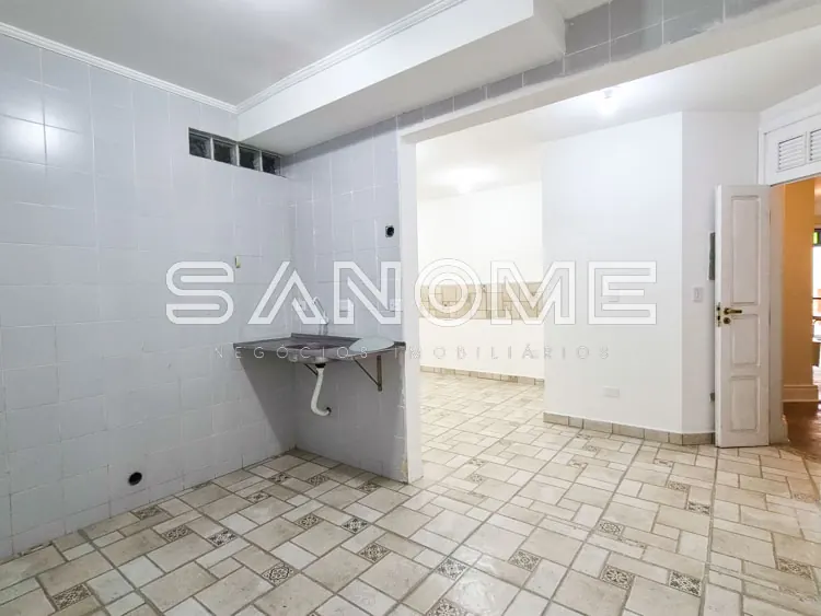 Cozinha com pia e parede de azulejos brancos