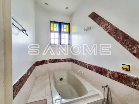 Banheiro com banheira embutida e azulejaria marrom