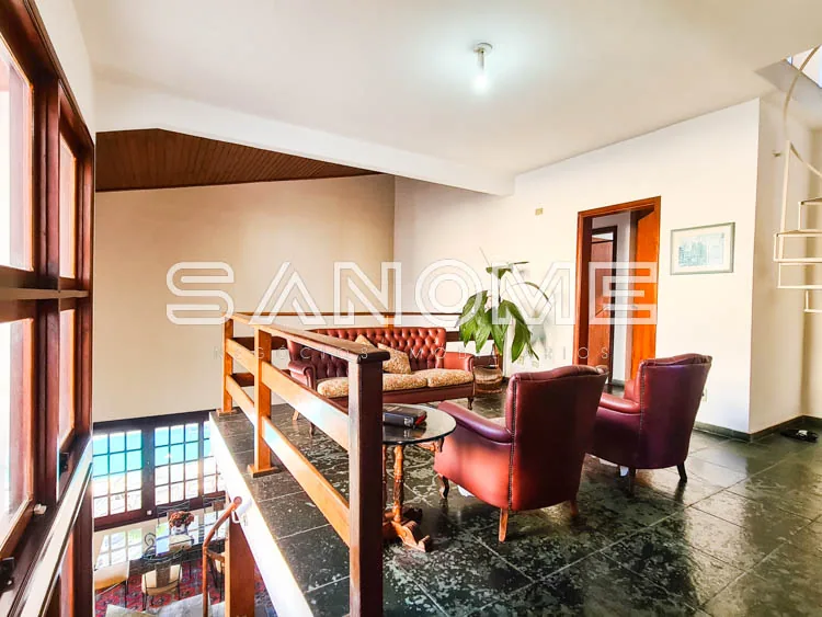 Sala com sofá vermelho e poltronas em tons quentes
