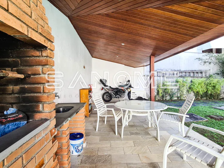 Área de lazer com churrasqueira e mesa de refeições