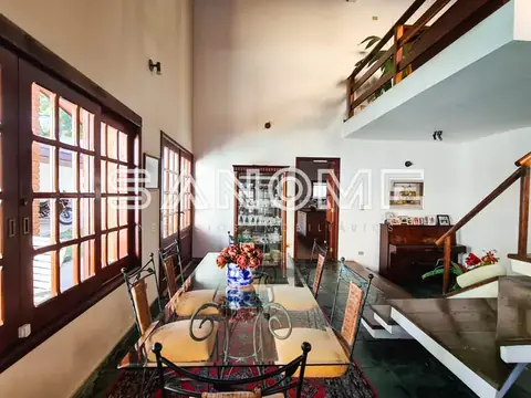 Sala de jantar com mesa de vidro e porta de vidro