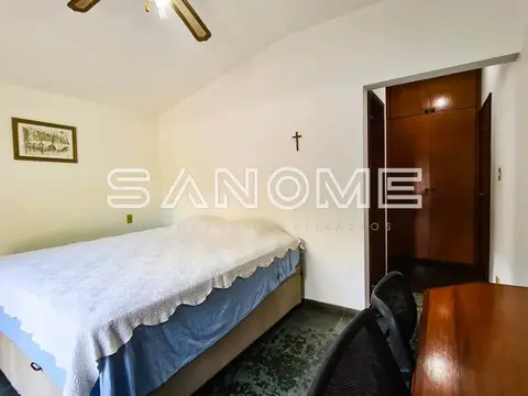 Quarto com cama de casal e móveis de madeira