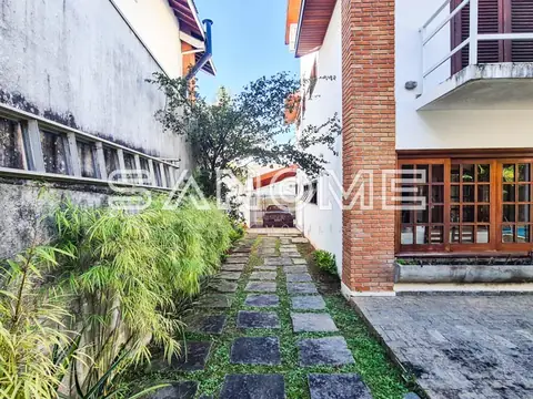 Corredor interno com piso de pedra e plantas