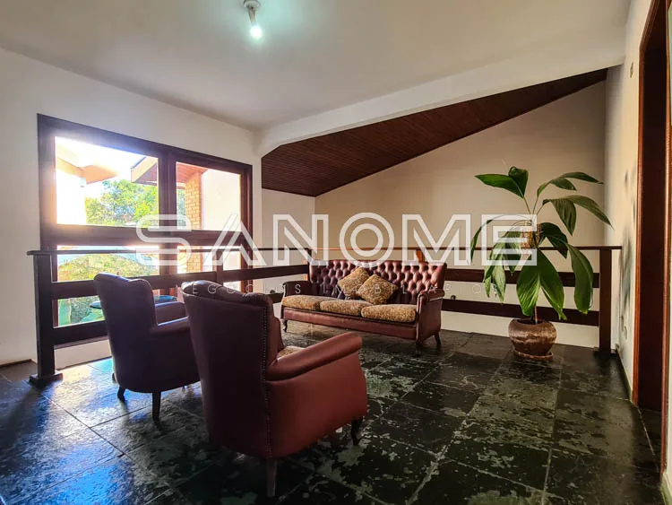 Sala de estar com poltronas de couro e sofá estofado
