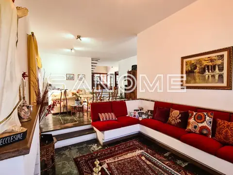 Sala de estar com sofá vermelho em L e tapete persa