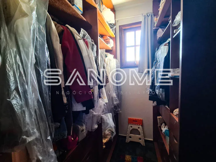 Closet com roupas penduradas e prateleiras