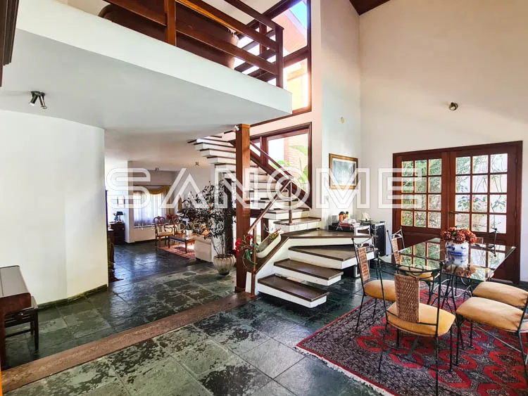 Sala com escada de madeira e piso de pedra